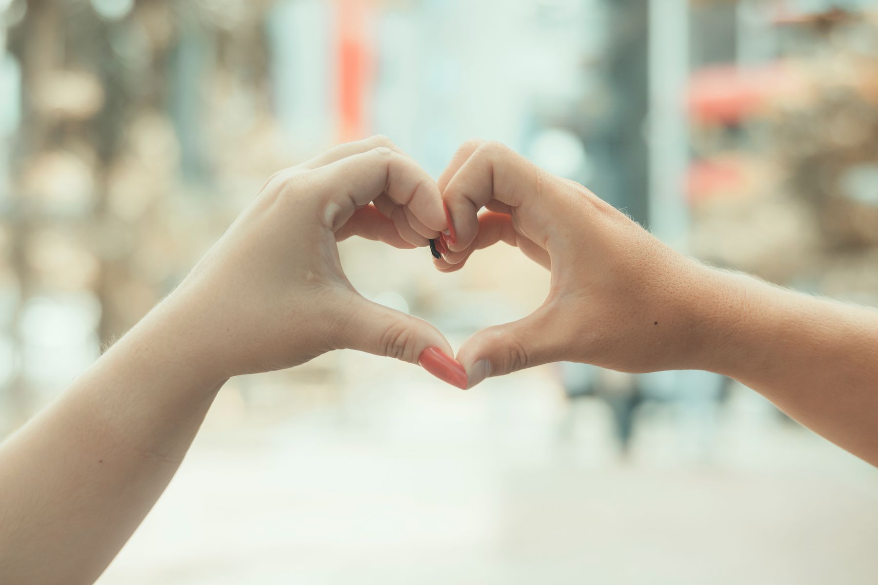 Hands forming a heart shape in a warm outdoor setting